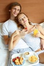 Young couple have breakfast in bed Royalty Free Stock Photo