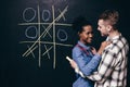 Young couple have fun leisure, play tic tac toe Royalty Free Stock Photo