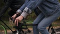 Young couple have fun riding on bikes in autumn park. Footage of rudders with hands. People, activity, leisure concept