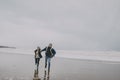 A Young Couple Run Along A Winter Beach Royalty Free Stock Photo