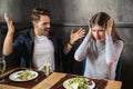 Young couple having arguments on date in restaurant