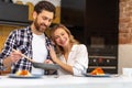 Young couple having breakfast in kitchenn, man serving dinner, woman sitting at table. Royalty Free Stock Photo