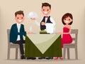 A young couple having dinner in a restaurant. Man and woman sitting at the table, the waiter brought a dish. Royalty Free Stock Photo