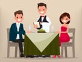 A young couple having dinner in a restaurant. Man and woman sitting at the table, the waiter takes order dishes. Royalty Free Stock Photo