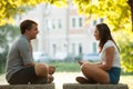 Young couple having fun on a bench in park while socializing over web Royalty Free Stock Photo