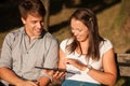 Young couple having fun on a bench in park while socializing over web Royalty Free Stock Photo