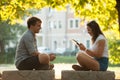 Young couple having fun on a bench in park while socializing over web Royalty Free Stock Photo