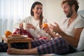 A young couple having fun while having breakfast in the bed. Love, relationship, together Royalty Free Stock Photo