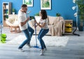 Young couple having fun while cleaning their flat Royalty Free Stock Photo