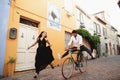 Young couple having fun while cycling. Love story in the old city of Italy Royalty Free Stock Photo