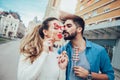 Young couple having fun holding artificial mustache and lips