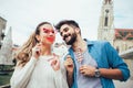 Couple having fun holding artificial mustache and lips stick