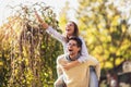 Couple having fun man giving piggyback to woman in park Royalty Free Stock Photo