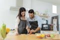 Young couple having fun while preparing breakfast together in a beautiful morning, cooking together, kitchen relationship, slicing Royalty Free Stock Photo