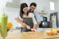 Young couple having fun while preparing breakfast together on a beautiful morning, cooking together, kitchen relationship, slicing Royalty Free Stock Photo