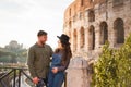 Young couple having fun in Rome with Colosseum as background - Lovers having italian vacation tour - Travel, love and romance