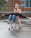 Young couple having fun on shopping trolley. Happy woman pushing shopping cart with her boyfriend inside Royalty Free Stock Photo