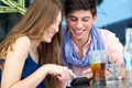 Young couple having fun with smartphones, outdoors