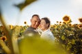 Young couple having fun during the summer day on the sunflower field. Man and woman hug and kiss and being happy showing Royalty Free Stock Photo