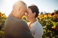 Young couple having fun during the summer day on the sunflower field. Man and woman hug and kiss and being happy showing Royalty Free Stock Photo