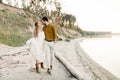 A young couple is having fun and walking on the sea coastline. Newlyweds looking at each other with tenderness. Romantic Royalty Free Stock Photo