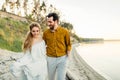 A young couple is having fun and walking on the sea coastline. Newlyweds looking at each other with tenderness. Romantic Royalty Free Stock Photo