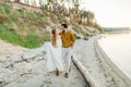 A young couple is having fun and walking on the sea coastline. Newlyweds looking at each other with tenderness. Romantic Royalty Free Stock Photo