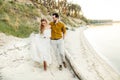 A young couple is having fun and walking on the sea coastline. Newlyweds looking at each other with tenderness. Romantic Royalty Free Stock Photo