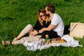 Young couple having a picnic on a spring grassfield in a countryside Royalty Free Stock Photo