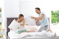 Young couple having pillow fight in bed Royalty Free Stock Photo