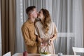 A young couple is having a romantic dinner together at home - a man and a woman kiss passionately near the table. Royalty Free Stock Photo