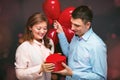 Young couple with heart shaped red balloons near grey wall Royalty Free Stock Photo