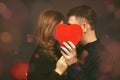 Young couple with heart shaped red balloons near grey wall Royalty Free Stock Photo