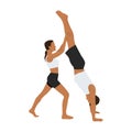 Young couple helping each other to practicing yoga. Woman helps a man doing handstand yoga exercise