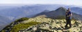 Young couple hike in Carpathian mountains. Man and woman standing on mountain top looking at beautiful landscape below. Wide panor Royalty Free Stock Photo