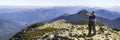 Young couple hike in Carpathian mountains. Man and woman standing on mountain top looking at beautiful landscape below. Wide panor Royalty Free Stock Photo