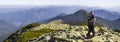 Young couple hike in Carpathian mountains. Man and woman standing on mountain top looking at beautiful landscape below. Wide panor Royalty Free Stock Photo