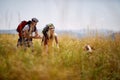 Young couple hiking in field, cudling with dog. Sport, freedom, holiday concept