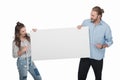 Young couple holding blank white card and pointing at copy space Royalty Free Stock Photo