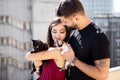 Young couple holding cats in hands on the terrace