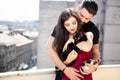 Young couple holding cats in hands on the terrace