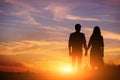 Young couple is holding hands on a background sunset silhouette Royalty Free Stock Photo