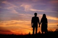 Young couple is holding hands on a background sunset silhouette Royalty Free Stock Photo