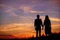 Young couple is holding hands on a background sunset silhouette Royalty Free Stock Photo