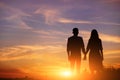 Young couple is holding hands on a background sunset silhouette Royalty Free Stock Photo