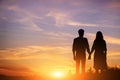 Young couple is holding hands on a background sunset silhouette Royalty Free Stock Photo