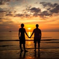 Young couple holding hands on the beach at sunset Royalty Free Stock Photo