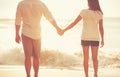 Young Couple Holding Hands on the Beach at Sunset Royalty Free Stock Photo