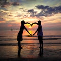 Young couple holding hands heart-shaped at sunset Royalty Free Stock Photo