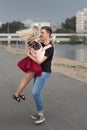 Young couple holding hands and smiling while walking through the street. Man carrying woman on his hands Royalty Free Stock Photo